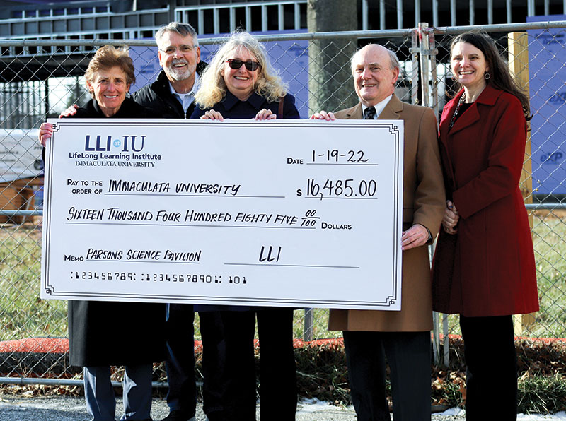 Five people holding an oversized check