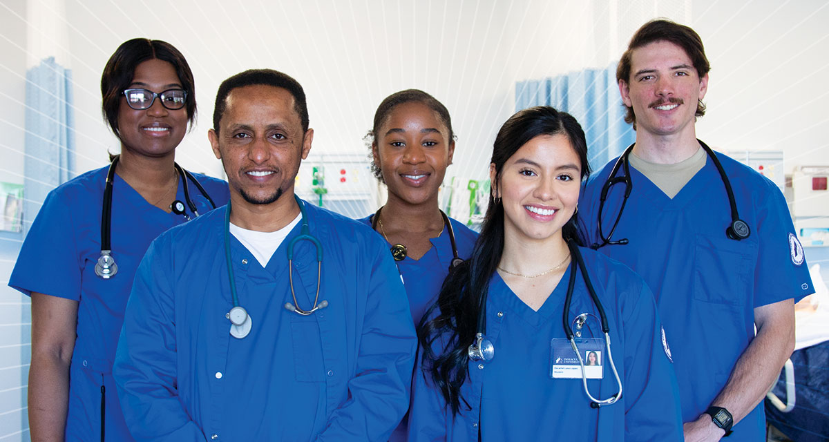 Five nursing students wearing blue scrubs