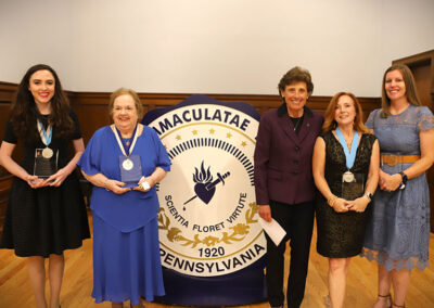 Five women standing in front of university seal