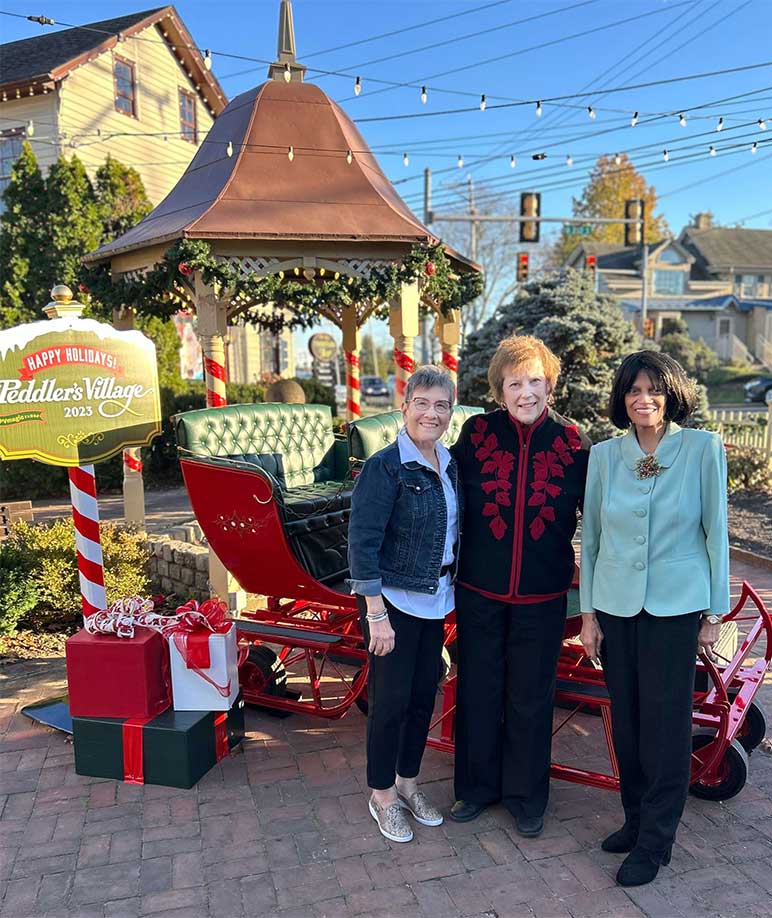 Three women in front of Christmas display at Peddler's Village