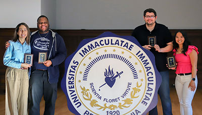 Four students holding awards