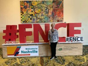 Woman standing in front of sign #FNCE