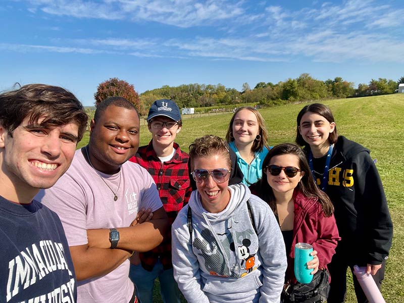 Group of young people with nun smiling for a selfie