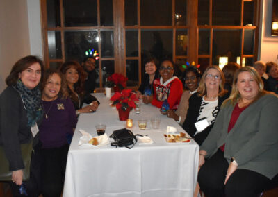 A group of people sitting around a table decorated for Christmas
