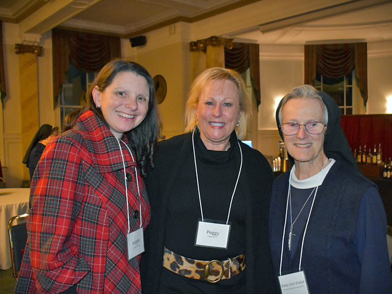 Two women and a nun, all wearing nametags around their necks