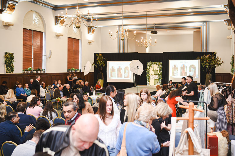 Crowd of people in hall looking at fashion exhibits