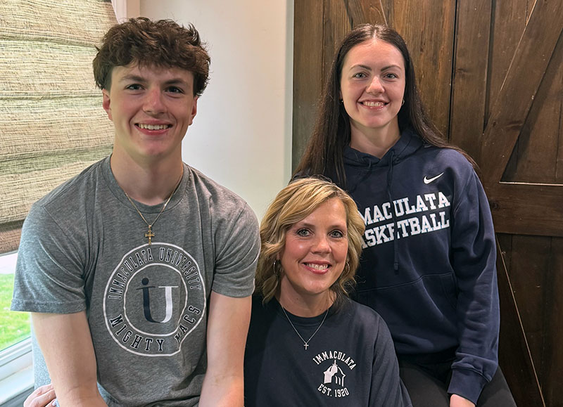 A young man, a woman and a young woman, all wearing shirts with "Immaculata University"